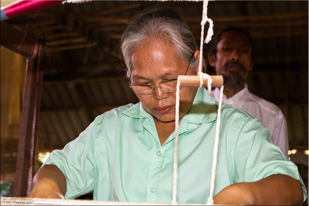 Elderly Thai Woman at the Head of a two-story silk loom