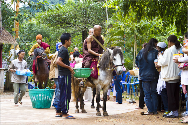 Monks on horseback collect food, water and other goods from supporters.