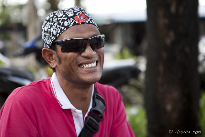 Portrait: Thai man in skull-and-crossbones headscarf and sunglasses.