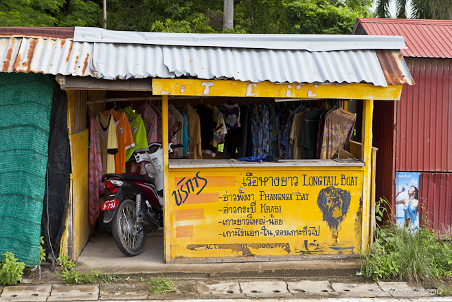 Yellow tour-shop hut front: motorcycle parked in the doorway.