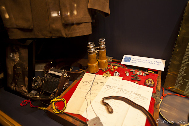 Museum display: papers, binoculars camera and clothing and medals from early 1900