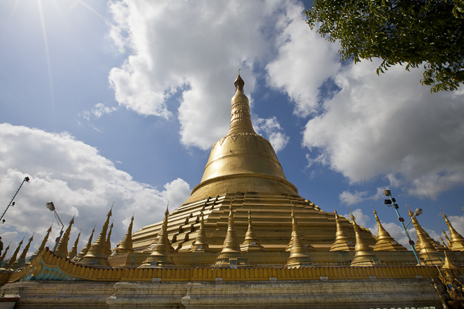 The golden Shwemawdaw Temple in afternoon light against fluffy white clouds. Bago (Pegu), Myanmar