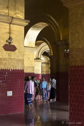 A group of Burmese people reflected in the floors of Mahamuni Temple, Mandalay, Myanmar