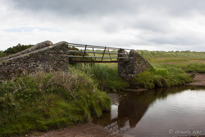 Small stone and metal bridge over a small, quiet creek; Castlegregory, Dingle Peninsula, Ireland