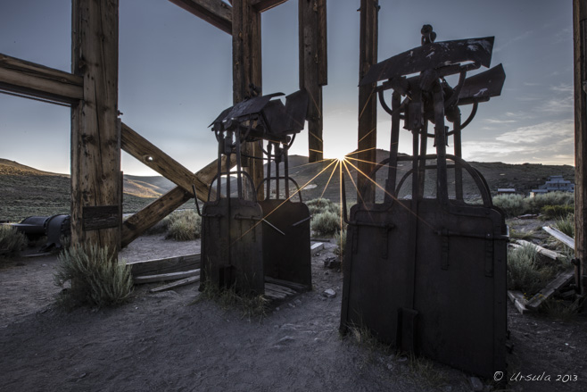 Sun rays through the wooden head frame and rusty man lifts, Bodie SHP, California, USA