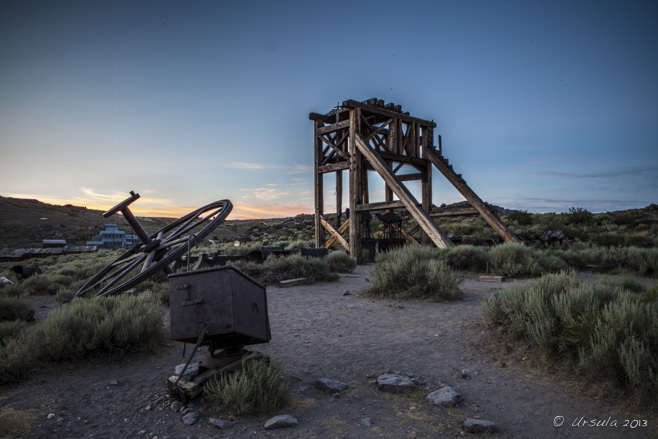 Rusty bits of machinery and an old wooden head-frame in dawn light, Bodie SP, CA, USA