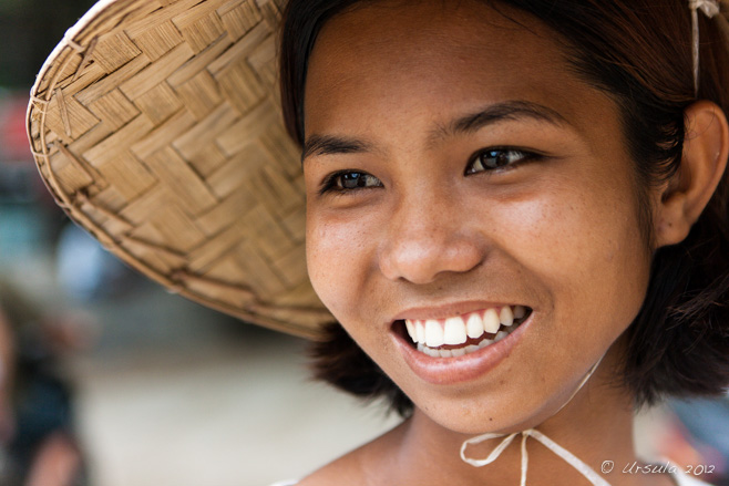 Portrait: Beautiful young smiling burmese woman in a straw bonnet.