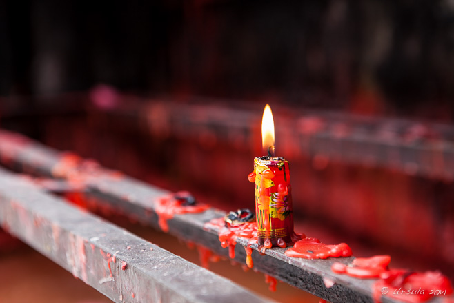 Red candle with gold paint burning on an alter, Kaiyuan Temple Quanzhou China