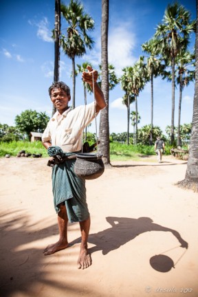 Burmese Man in a longhi with a metal pot, Bagan