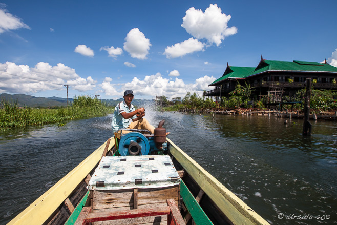 Burmese man on the controls of a longtail boat, Inle Lake, Myanmar