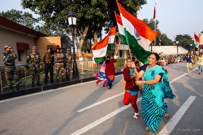 Mother and child running with an Indian flag, Wagah Border, Amritsar Punjab India