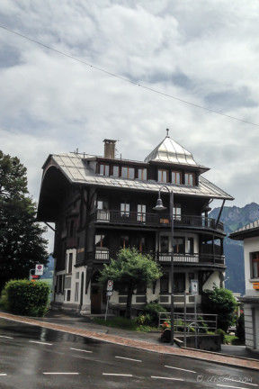 Wooden multi-story house with a shiny metal roof, Leysin CH