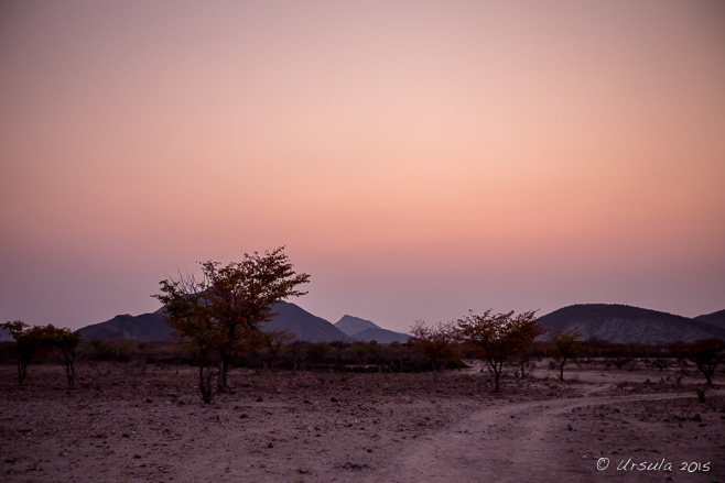 Pink light over a dirt road into the hills around Otjomazeva, Namibia 