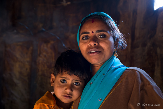 Rajasthani mother and boy in a dark room, Thar Desert village, India