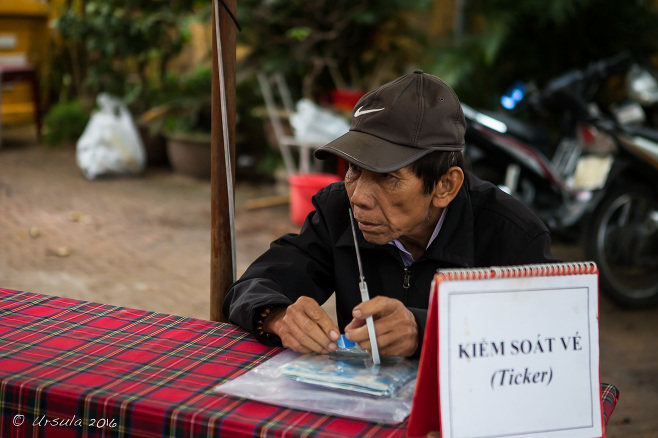 Vietnamese man at a ticket taking table, Hoi An Old Town, Vietnam