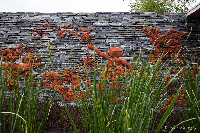 Grey stone wall with terracotta mural of Vietnamese farmers, Naman Retreat, Đà Nẵng