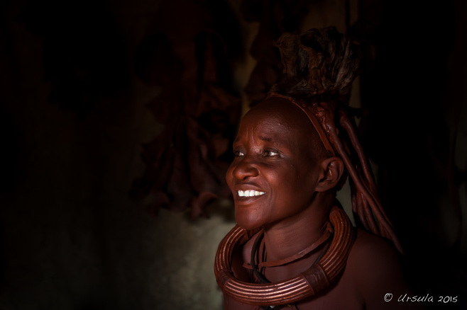 Portrait of a smiling Himba Woman in a dark hut, Kunene Namibia