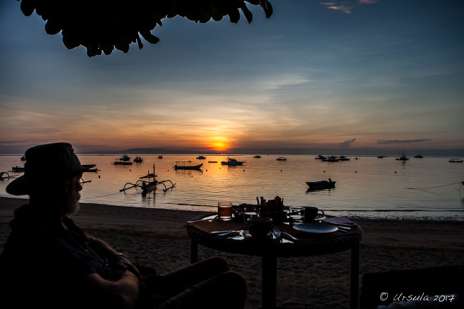 Silhouette of a seated man at sunrise, Sanur Beach Bali