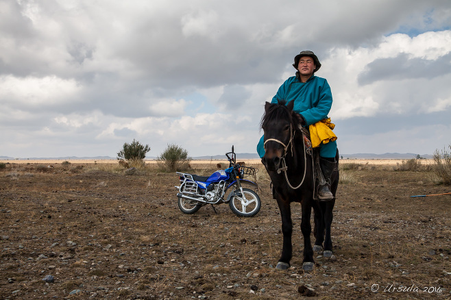 Nomad on the Horseback with a motorcycle in the background, Uvs Province Mongolia