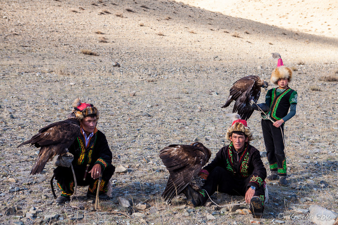 Three Kazaks on a rocky hill with their eagles, Bayan-Ölgii Mongolia