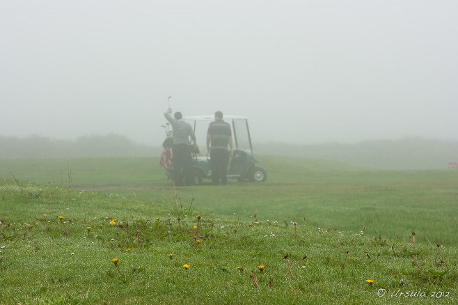 Men with a golf buggy in the fog, Cape Cornwall Golf Course, UK