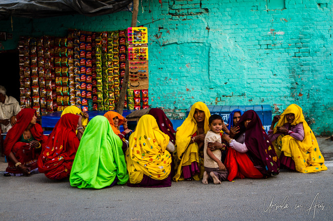 Indian woman in colourful ghoonghats outside a shop, Haridwar.