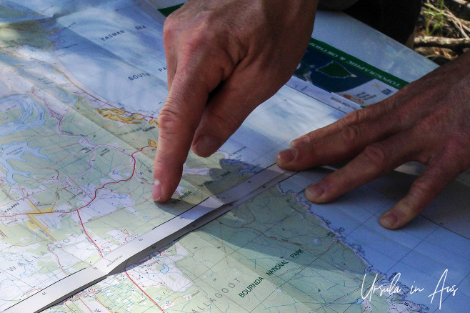 Hands on a map of Bournda National Park, NSW Australia