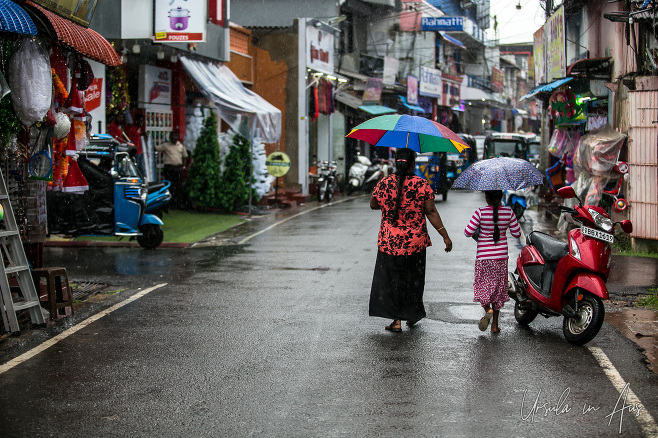 Woman and child with umbrellas in Main Street Batticaloa, Sri Lanka