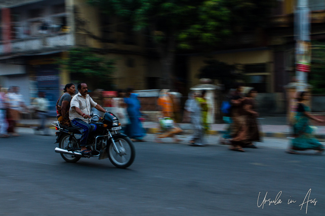 Motorcycle on the move against blurry walking people, Haridwar India