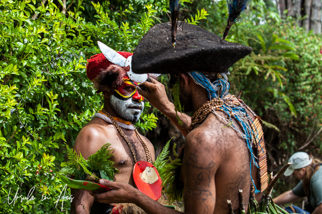 Western Highlands man applying face-paint to another, Paiya Village, Papua New Guinea.