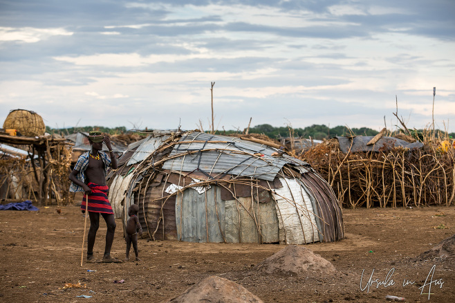 Daasanach man outside a corrugated iron hut, Omo Valley Ethiopia