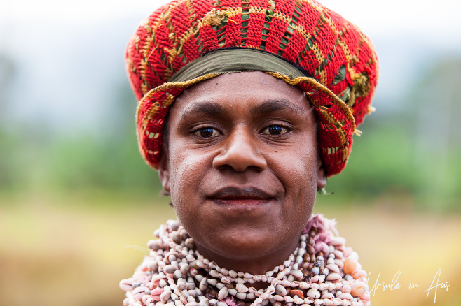 Portrait: Western Highland Papuan Woman in a bilum hat ans shell necklace.