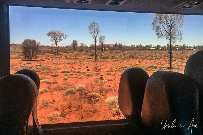 Uluru in the distance through a bus window, Yulara NT Australia