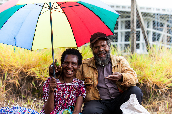 Papuan couple under a rainbow umbrella, Mount Hagen, PNG