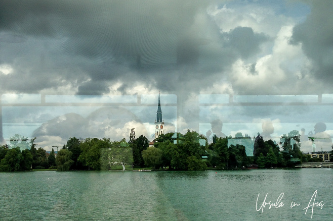 Reflections of people eating against a rainy shoreline on Lake Zug, Switzerland 