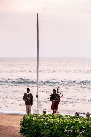 Two men, one in tartan one in hotel uniform, at the Galle Face Hotel flagpole, Colombo Sri Lanka