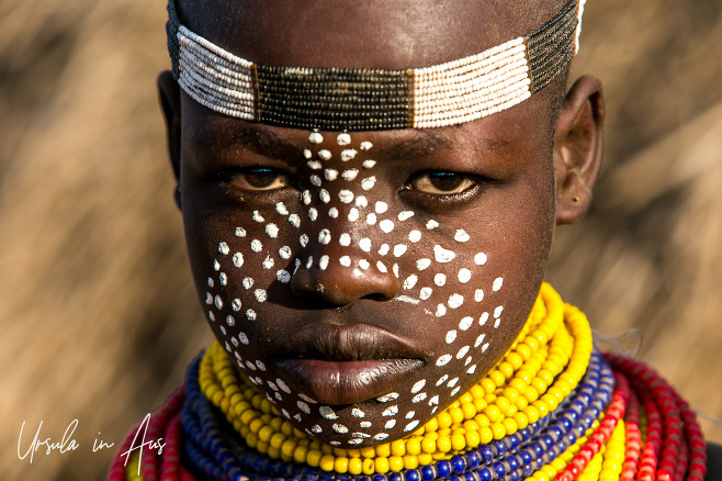 Portrait: A young Kara girl in beads and face paint, Dus Village Ethiopia