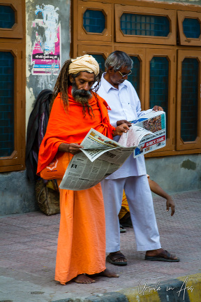 Hindu men in the street reading their papers, Haridwar