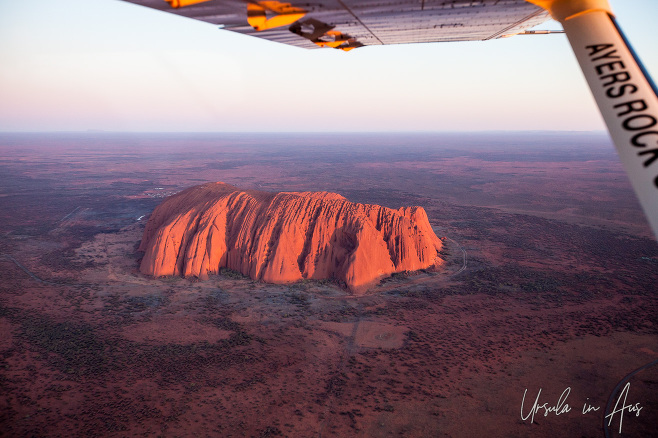 Aerial view of Uluru under the strut of a small plane, Yulara NT Australia 