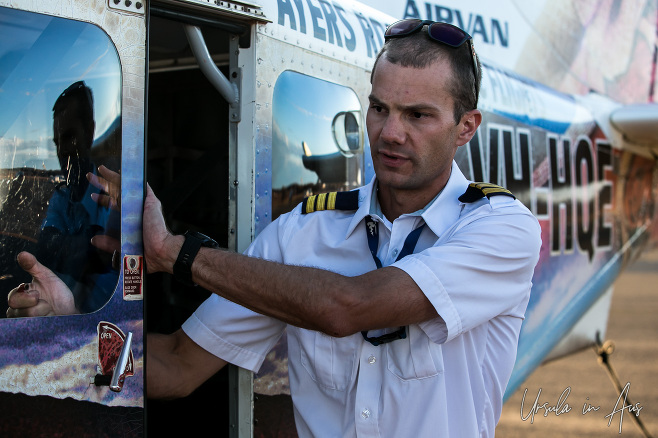 Young pilot at the door of an Ayers Rock Scenic Flight airplane, NT Australia