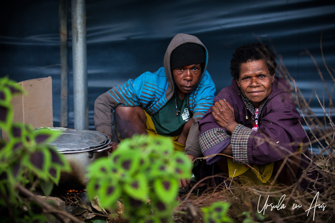 Papuan man and woman outside with a large cooking pot, Mt Hagen PNG