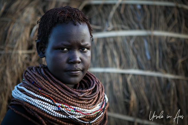 Portrait: Nyangatom Woman in brown and white beads, Omo Valley Ethiopia
