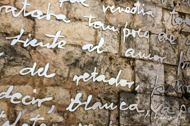 Spanish script in white on perspex over brick, Santander Spain