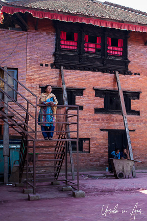 Nepali woman on a scaffolding stairway, Courtyard of the Living Goddess, Kathmandu Nepal