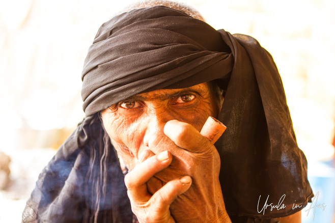 Portrait: Sadu in a black headscarf smoking a chillum, Varanasi, India.