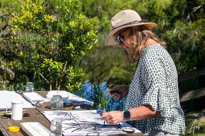 Woman painting in Panboola Wetlands, Pambula NSW Australia