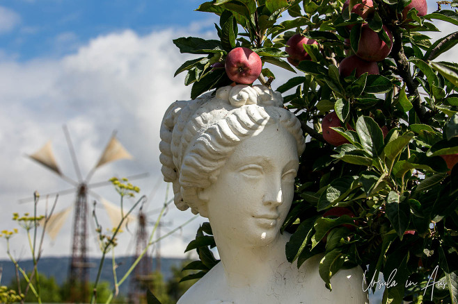 White statue of a woman in an apple orchard watered by windmills of the Lassithi, Greece