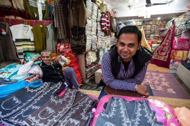 Men in a shop selling felt vests and embroidered fabrics, Haridwar India