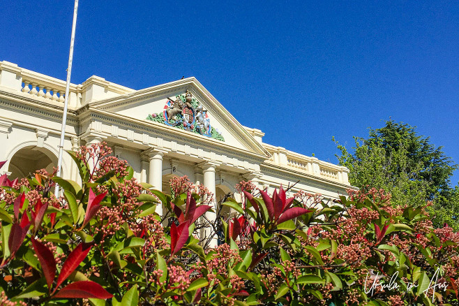 Rooftop of the heritage Yass Valley Courthouse over a colourful hedge, NSW Australia