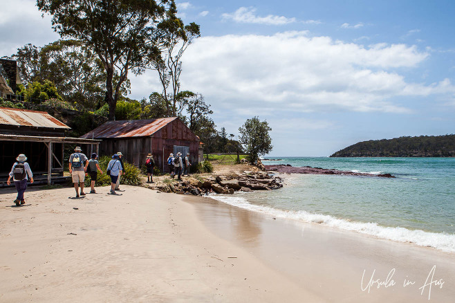 Walkers on the beach at the mouth of the Pambula River, NSW Australia